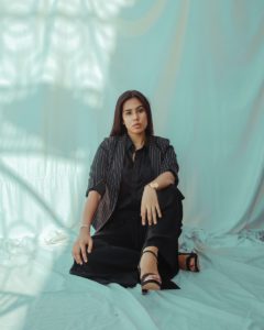 woman in black dress sitting on white textile